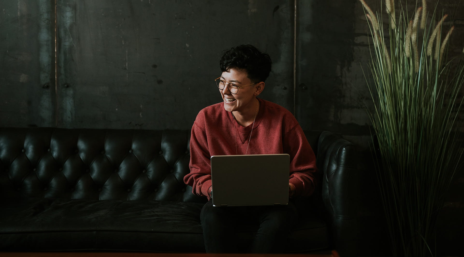 Person sitting on coach with laptop at table