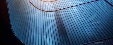 Abstract close-up of a curved metallic architectural structure with blue ribs and gold trim on dark background
