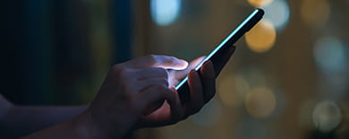 Hand holding a smartphone with blue glow used in Privacy Solutions built for Global Compliance campaign.