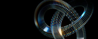 Three interlocking ribbed rings with prismatic rainbow light effects on a black background.