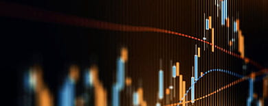Financial candlestick chart on a dark screen showing a market decline followed by a sharp recovery.